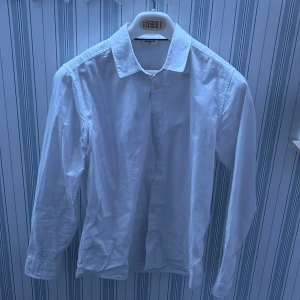 Vit skjorta från Kappahl - !Behövs bara strykas annars är den perfekt!Säljer en klassisk vit skjorta från Kappahl. Skjortan har långa ärmar och knappar framtill. Perfekt för en stilren look. Passar till många olika tillfällen och stilar.