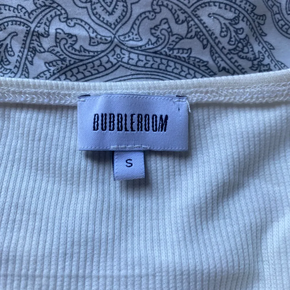 Säljer är vit/krämvit långärmad topp från bubbleroom. Den har en fin omlottdesign framtill vilket gör att den har en väldigt fin passform. Använd ett fåtal gånger . Yläosat.