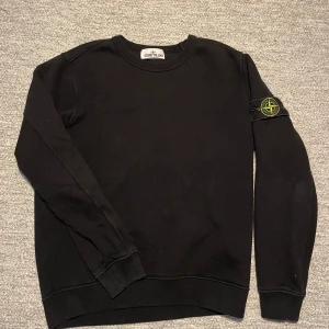 Stone Island sweater  - Säljer en stilren svart tröja från Stone Island med deras ikoniska märke på ärmen. Riktigt bra skick storlek S, perfekt till våren och sommarkvällar
