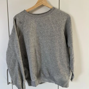 Grå sweatshirt i bomull - En klassisk grå sweatshirt med rund hals och långa ärmar. Tröjan är i damstorlek men funkar för alla, har ribbade muddar vid ärmslut och nederkant. Perfekt för en avslappnad stil och enkel att matcha med andra plagg. Pris går att diskutera🥰