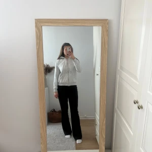 Grå zip-hoodie med huva - Säljer en enkel och stilren grå zip-hoodie med huva och dragsko. Jackan har långa ärmar, dragkedja framtill och ribbade muddar vid ärmslut och nederkant. Perfekt för en avslappnad look. 