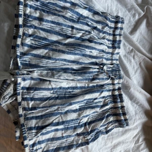 Randiga mjukisshorts med knytband - Snygga shorts med blå och vita ränder och elastisk midja. Knytband framtill för extra passform. Perfekta för varma dagar och avslappnad stil.