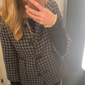 Svart/grårutig trekvartsärmad jacka - Supersnygg svart och grårutig trekvartsärmad jacka. Jackan är från Lindex och är sparsamt använd.