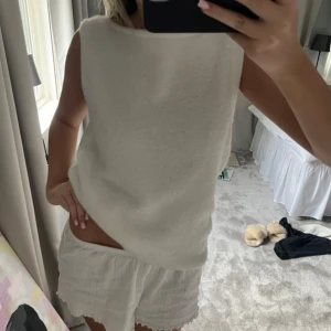 Vit ärmlös topp - Säljer en stilren vit ärmlös topp med rund hals. Perfekt för en avslappnad och chic look. Passar bra till både kjol och byxor.