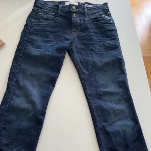 Mörkblå Replay Hyperflex jeans - Säljer ett par mörkblå Replay Hyperflex jeans med klassisk femficksdesig. Jeansen har normal passform och raka ben, perfekt för dig som vill ha bekväma och stilrena jeans till vardags. Har knapp använt dessa, de ligger mest bara i garderoben.