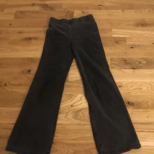 Svarta manchesterbyxor från H&M - Säljer ett par svarta manchesterbyxor från H&M med utsvängda ben. Byxorna har en klassisk bootcut-stil och är tillverkade i mjuk manchester. Perfekta för dig som gillar retrovibbar och vill ha något bekvämt men ändå snyggt.