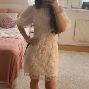 Studentklänning från YAS - Superfin vit spetsklänning från YAS med puffiga korta ärmar som funkar perfekt för studenten! Säljer den eftersom jag valde en annan klänning att ha till studenten, så den är ny med prislapp på och aldrig använd. Skriv för frågor 💕