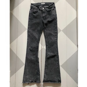 Utsvängda jeans med låg midja  - Gråa utsvängda jeans med låg midja från Gina Tricot. Lite fransiga nertill, men är absolut inte något som stör.