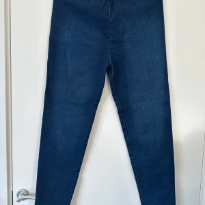Mörkblå jeansbyxor från Jordache - Säljer ett par mörkblå jeansbyxor från Jordache. Byxorna har en rak passform och är tillverkade i ett robust men lätt elastiskt denimtyg. Perfekta för dig som gillar en tidlös stil med enkel design.