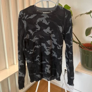 100% Kashmir camouflage-mönstrad tröja från Zadig & Voltaire - Snygg långärmad tröja från Zadig & Voltaire i grått och svart camouflage-mönster. 100% Kashmir. Sitter lite tight så passar även size S. Ett hål på vånstra armbågen.