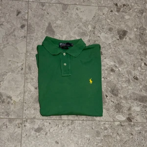 Grön pikétröja från Polo Ralph Lauren - Säljer en klassisk grön pikétröja från Polo Ralph Lauren. Ett väldigt bra val till sommaren. Inte bästa kvaliten därav priset på denna. Nypris cirka 1600