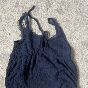 Marinblå spetstopp från Gina Tricot - Säljer en marinblå topp från Gina Tricot i storlek XS. Den har smala axelband och är täckt av vacker spets💞