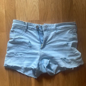 Ljusblå jeansshorts, Low waist - Ljusblå jeansshorts med råa kanter och slitna detaljer från &Denim. Low waist. 