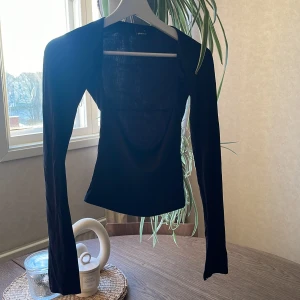 Svart långärmad topp från Gina Tricot - Säljer en svart långärmad topp från Gina Tricot. Toppen har en tight passform och är tillverkad i ett mjukt, stretchigt material. Perfekt att styla med jeans eller kjol för en enkel och stilren look.