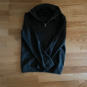 Half zip hoodie  - Mysig mörkgrå stickad tröja med hög krage och halv dragkedja framtill. Perfekt för kyligare dagar och enkel att matcha med olika outfits. Klassisk och stilren design. Från Jack and Jones