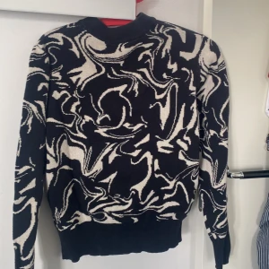 Svart och vit mönstrad tröja från Monki - Cool svart tröja från Monki i storlek XXS med abstrakt vitt mönster. Tröjan har långa ärmar och ribbade muddar vid ärmslut och nederkant. 