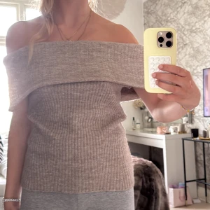 Beige ribbad offshoulder stickad topp - Superfin beige stickad topp med bred offshoulder-krage och ribbad struktur. Sitter snyggt och är perfekt för dig som gillar en stilren men ändå trendig look. Mjuk och skön, passar till både jeans och kjol. Den var långärmad först men jag gjorde den kortärmad.