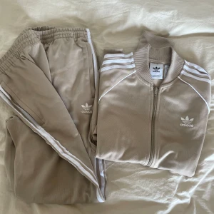 Adidas mjukis-set  - Adidas mjukis-set beige/vit. Tröja i storlek M. Byxor i storlek L. 200kr/styck. 400kr för båda. 