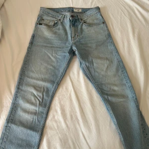 Ljusblå jeans från Tiger of Sweden - Snygga ljusblå jeans från Tiger of Sweden med klassisk femficksdesign och raka ben. Jeansen har en normal passform och är tillverkade i mjukt bomullsjeans. Perfekta för dig som gillar stilrena och tidlösa jeans med modern känsla.