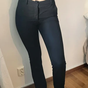 Svarta kostymbyxor - Snygga svarta kostymbyxor med smal passform, pösiga nertill. Använda ett fåtal gånger. Små i storleken, ska kunna passa en 34 💕
