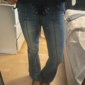 Jeans med snörning  - Snygga lågmidjade bootcut jeans med snörning fram! Midja:39, inneben:76
