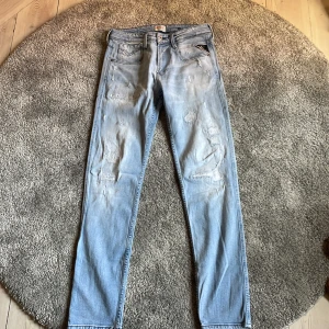 Replay ljusa anbass jeans herr 29/32 - Säljer ett par ljusblå anbass jeans från Replay i storlek 29/32. Jeansen har slitna detaljer och klassisk femficksdesign. Perfekt för dig som gillar en smal passform och en trendig, avslappnad look.