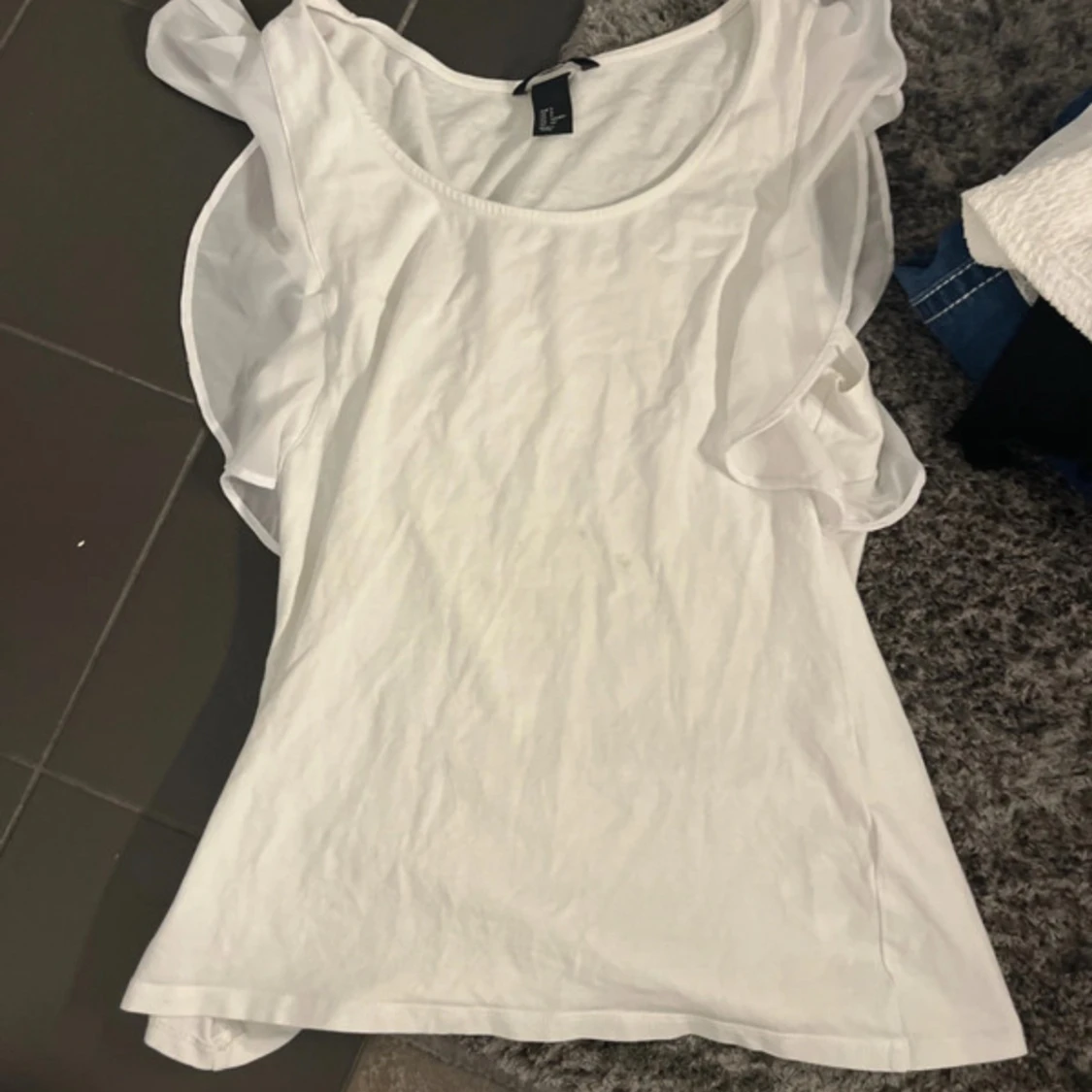 Vit ärmlös topp med volang