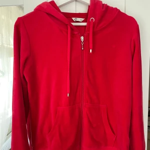 röd kofta - Snygg röd kofta i mjukt material med dragkedja framtill, huva med snörning och  fickor. Perfekt för chill dagar eller när du vill ha en poppig färg i din outfit. Klassisk passform och långärmad modell.
