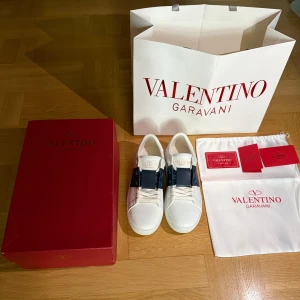 Valentino Garavani Open sneakers vit/blå - Valentino Garavani, helt nya med storlek 35. Priset kan diskuteras vid snabb affär. Kommer med originalkartong, dustbag och påse. Skriv privat vid frågor och funderingar. 