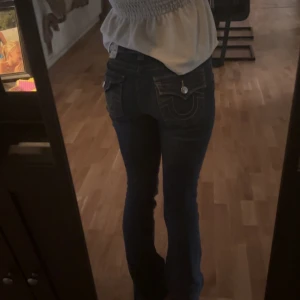  True religion jeans Mörkblå bootcut  - Storlek: W26 modell: Becca mid rise                         Sitter jätte fint och är bara lite slitna på ena kanten typ som du ser på bilden. Säljer d för att d nt riktig kommer till användning längre. Skriv gärna om du har frågor💓💓💞 Ny pris: 1300kr.      Pris kan diskuteras💓💞