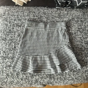 Rutig volangkjol från Kappahl - Supersöt kort kjol från Kappahl i svartvitt rutigt mönster. Kjolen är använd en gång så skicket är i 9/10.💕