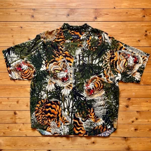 DSQUARED2 skjorta med tigerprint - Skjorta från DSQUARED2 med tigerprint i orange, svart, grön och beige. Korta ärmar, knappar framtill och tillverkad i tunn bomull. med djungelvibbar. Nypris 4000kr