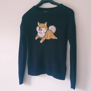 Svart stickad tröja med hundmotiv - Svart stickad tröja från FB Sister med ett gulligt broderat hundmotiv framtill. Tröjan har långärmad passform och grovstickad struktur som ger en mysig känsla. Perfekt för dig som gillar unika detaljer och vill sticka ut lite extra.   Liten tråddragning på ärmen finns men inga hål, små noppror