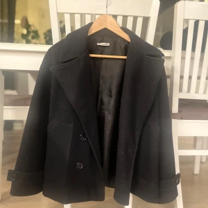 Marinblå kappa från design by si - Stilren marinblå kappa i gott skick, något nopprig vid kragen men inget som syns så tydligt. Storlek är xs/s skulle säga att den är mest som en S i storleken men passar absolut någon som har xs. Tvättad noggrant innan den skickas!