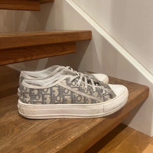 Grå Dior sneakers med monogram - Sneakers från Dior med grått mönster! Köptes för ca ett år sedan men är i bra skick. Tvättas innan jag postar och vill man ha tillhörande påse så skickas det med💕 