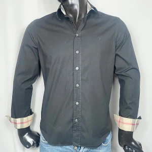Burberry skjorta - Svart Burberry skjorta med det ikoniska mönstret på krage och ärmar. Skick: 8/10. Retail: 4,800 SEK.