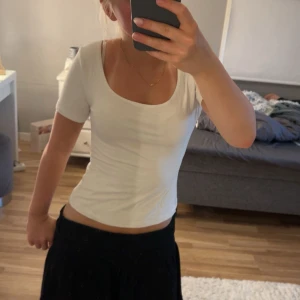 Vit croppad topp från BikBok - Säljer en enkel och fräsch vit croppad topp från BikBok. Toppen har rundad urringning, ärmlös design och sitter tight mot kroppen. 