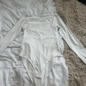 Vit långärmad bodysuit - Säljer en långärmad stilren body från H&M. Aldrig använt och den är helt ny. 