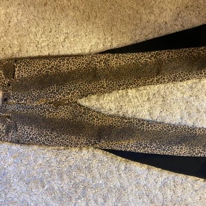 Leopardmönstrade jeans John Richmond - Ge förslag❗️Snygga jeans från John Richmond med leopardmönster i bruna och svarta toner. Passar storlek xs och s. Modellen är slim och har klassisk femficksdesign, knappgylf och svarta detaljer. Perfekta för dig som vill sticka ut med en edgy look.