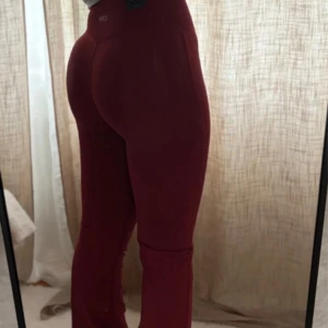 Burgundy flared tights från ICANIWILL - Säljer ett par burgundy röda tights från ICANIWILL med utsvängda ben och hög midja. De är sömlösa och har en tight passform upptill som blir flared nertill. 