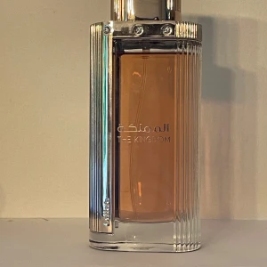 The Kingdom Eau de Parfum - Lattafa  The Kingdom her  med toppnoter av päron, pion och svarta vinbär. Mellannoter av pralin, tonkaböna och jasmin, samt basnoter av mysk, vanilj, sandelträ och amber.  100ml ca 95ml kvar!  Inspirerad av kayali wedding silk santal 36