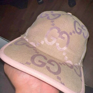 Gucci Beige och rosa keps  - Säljer en beige keps från Gucci med ikoniskt GG-mönster i ljusrosa och lila toner. 