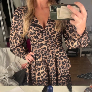 Leopardmönstrad kortklänning  - Snygg klänning med knappar vid ärmslut och dragkedja bak. Endast använd vid provning dvs ny skick utan defekter🐆🐆🐆💞💞Passar även stl xs då jag är de😊