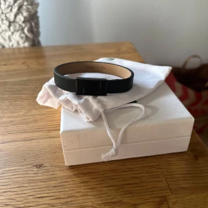 Svart armband från Lacoste - Säljer detta Lacoste armband i skinn då det var för stort för mig,armbandet är cirka 21cm långt. Kommer i original box, samt en påse skriv för fler bilder