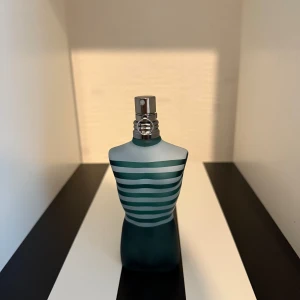 Le Male Jean Paul Gaultier parfymprov - Le Male från Jean Paul Gaultier i provflaska (2ml, 5ml eller 10ml). Doften är maskulin med inslag av vanilj, lavendel, kanel och amber. Flaskan är genomskinlig och påfyllbar, perfekt att ta med sig. Parfymen är känd för sin ikoniska blågröna torsoformade originalflaska. 2ml=30kr 5ml=50kr 10ml=100kr.