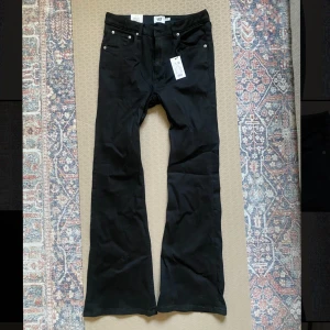 Svarta jeans Snake Flare - Svarta jeans från Lager 157 i modellen Snake Flare. Hög midja och utsvängda ben ger en snygg siluett. Klassisk femficksdesign och full längd. Perfekta för dig som gillar en trendig och bekväm look. Helt nya, för stora för mig.