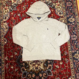 Grå Ralph Lauren hoodie - Den är i bra skick inga fläckar och är sparsamt använd storleken är 14-16 vilket motsvarar ungefär Xs skriv om du har frågor