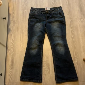 LEI Sophia hipster flare jeans - Mörkblå jeans från LEI, modell Sophia hipster flare. Snygg bootcut med låg midja och coola detaljer på bakfickorna med kontrastsömmar. Klassisk femficksmodell i jeansmaterial, perfekt för dig som gillar retrovibbar och flare.