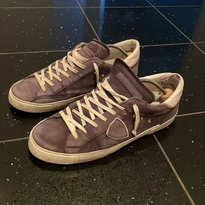 Philippe Model blå sneakers  - Snygga Philippe Model sneakers i blå nubuck med vita detaljer och platt sula. Klassisk låg modell med rund tå, vita snören och diskret logotyp på sidan. Skorna har en stilren vibe och passar perfekt till jeans eller chinos. Skokartong och extra skosnören medföljer. I använt skick men skorna ska se lite använda ut. Lite slitningar på dem. Storlek 45. Kostade 340 euro.