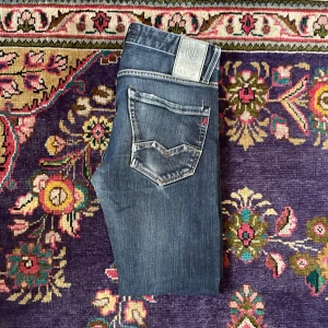 Replay jeans - Säljer ett par snygga Replay jeans i mörkblå tvätt med slitningar och klassiska kontrastsömmar. Jeansen är i w28 l30 men små i storleken. Jeansen är i sparsamt skick med inga defekter eller liknande. Hör av er vid minsta fundering!!